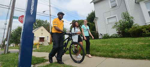 A safety patrol officer escorts two University of Akron students
