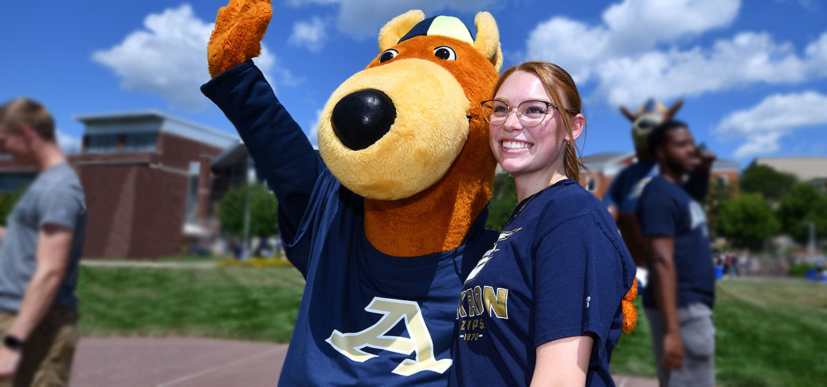 A transfer student with Zippy at ϲҳ hanging out on campus.